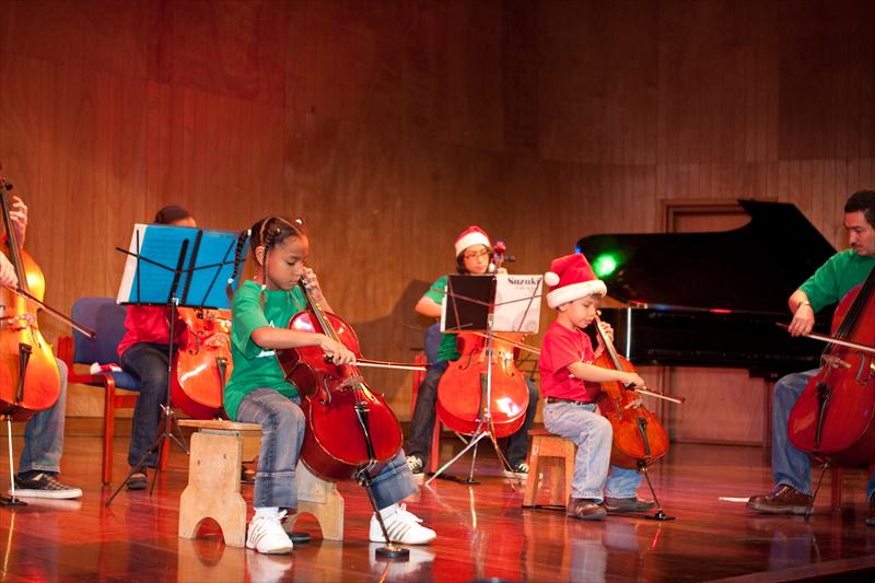 Niña tocando violonchelo en concierto navideño